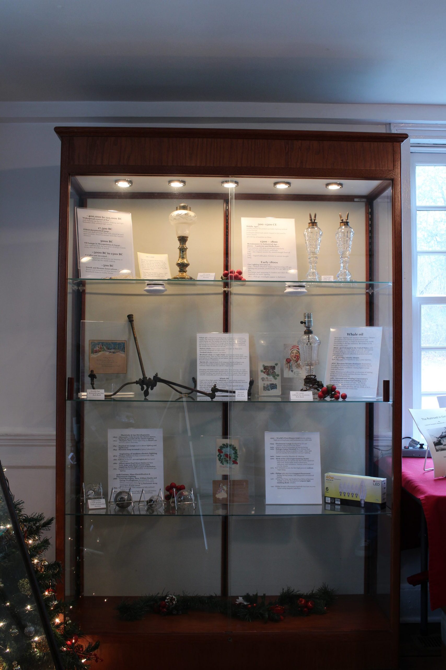 A modern display case with gas fixtures and vintage holiday postcards